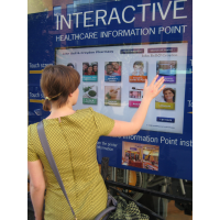 Eine Frau, die einen Durch-Fenster Selbstservice-Touch Screen Kiosk verwendet