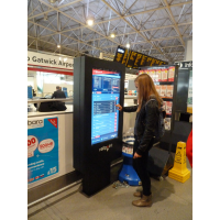 Ein Mädchen, das einen Touch Screen Kartenmaschinenzeitplan an einem Flughafen verwendet