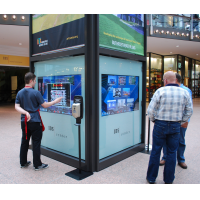 Leute, die einen interaktiven wayfinding Kiosk in einem Einkaufszentrum verwenden