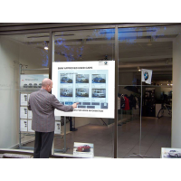 Un hombre que usa una ventana de tienda interactiva de PCAP touch foil