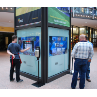 Personas que usan un quiosco interactivo de orientación en un centro comercial