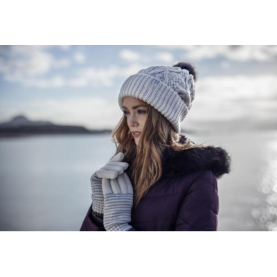 Una mujer con gorro y guantes de HeatHolders: el principal proveedor de ropa térmica.