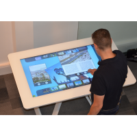 Un homme utilisant une table interactive en verre tactile