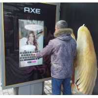 Un uomo che utilizza un display overlay touchscreen da 32 pollici a una fermata dell'autobus