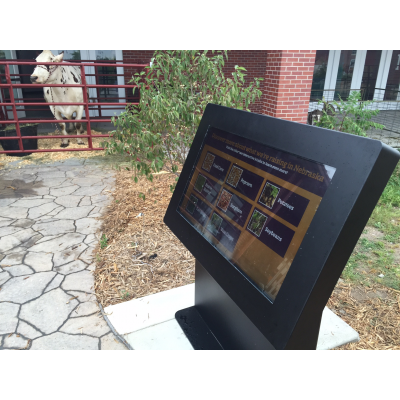 Multi-touch skjerm overlegg brukes til en kiosk med ku i bakgrunnen