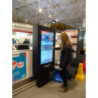 Uma menina usando uma máquina de check-in de tela de toque à prova de poeira